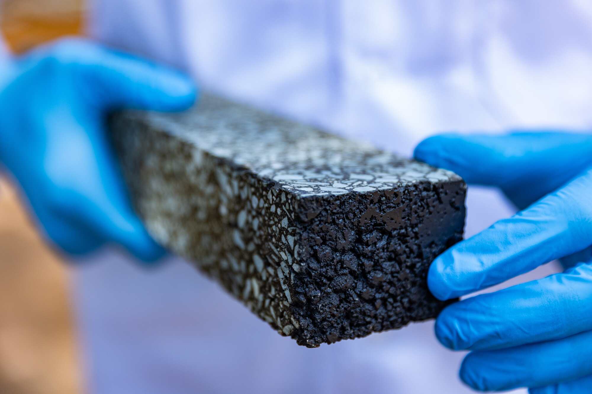 Person with gloves holding a 3D rectangular item