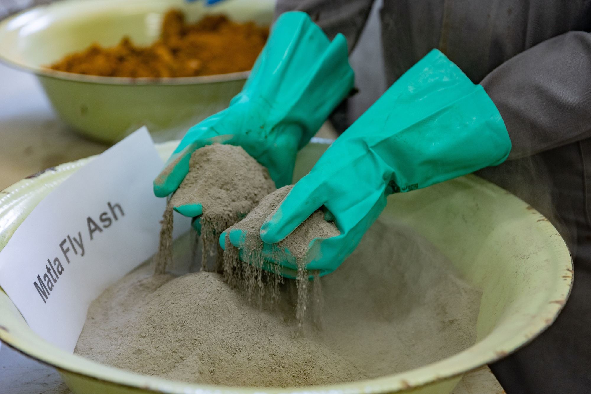 Person with gloves holding malta fly ash
