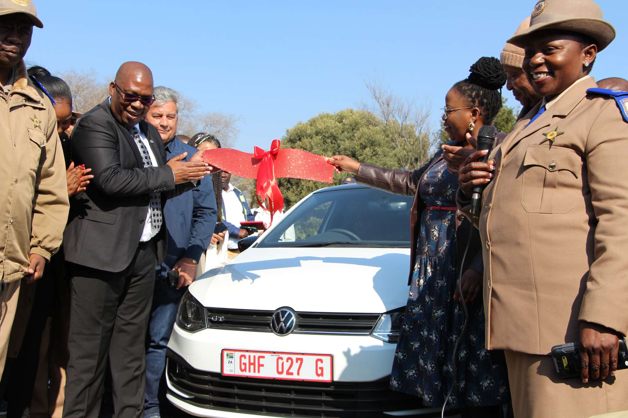 People standing in front of a car