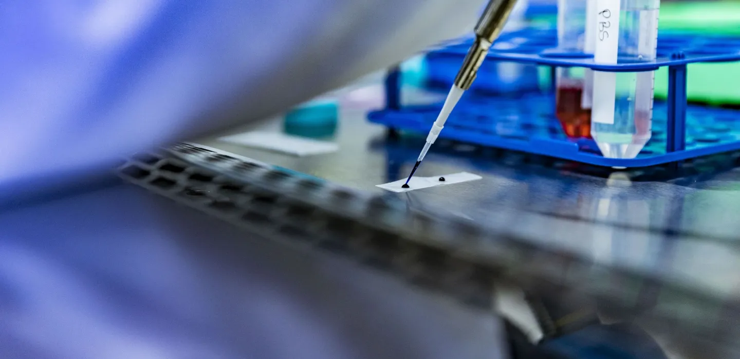 Scientist placing liquid on paper